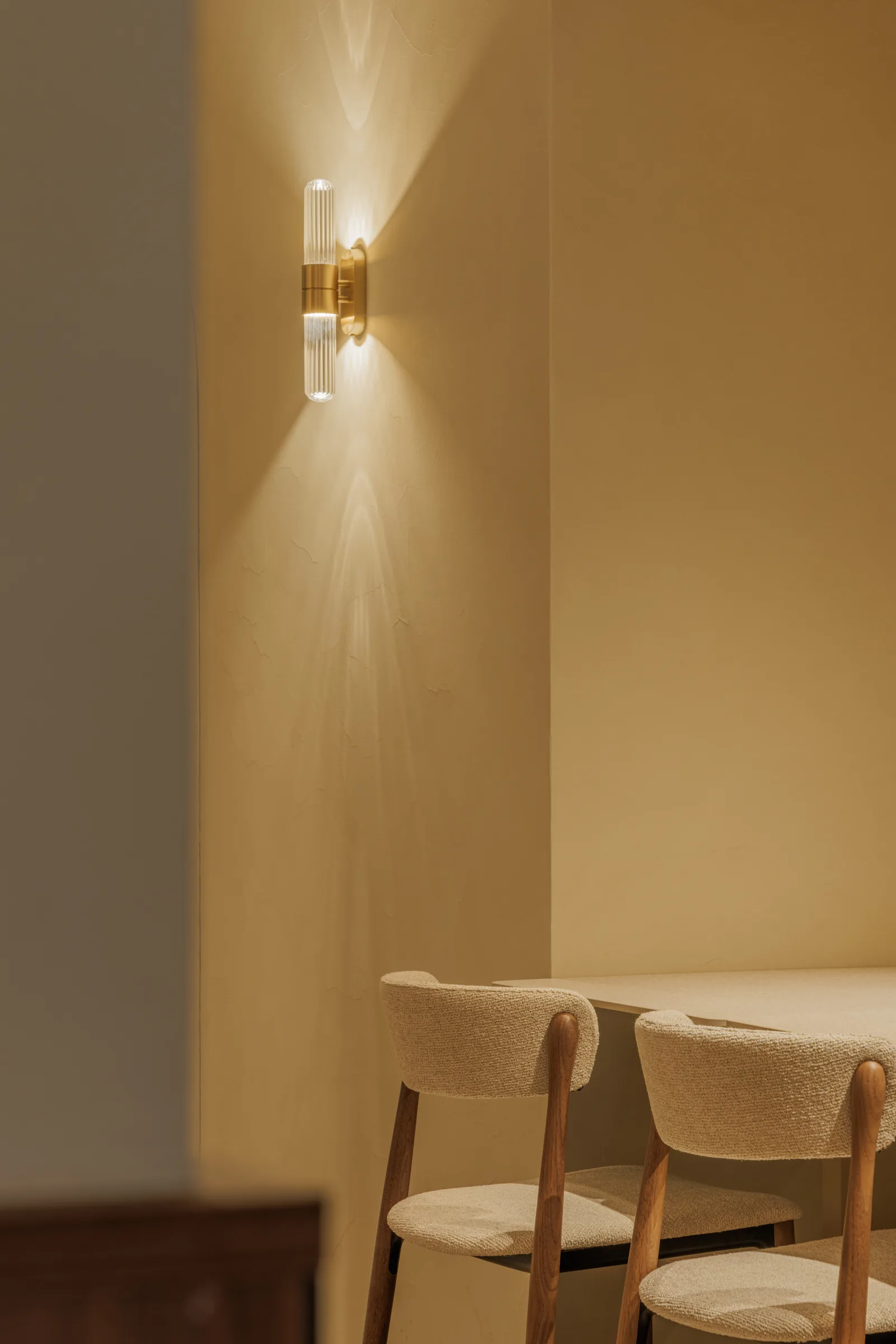 Wandlamp boven gestoffeerde stoelen